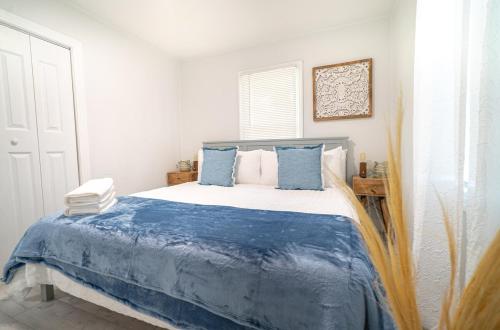 a bedroom with a bed with blue and white sheets at Homey Cozy Newly Renovated Stylish&chic 7 Guests in Tampa