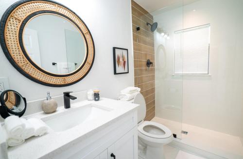 a bathroom with a sink and a toilet and a mirror at Homey Cozy Newly Renovated Stylish&chic 7 Guests in Tampa