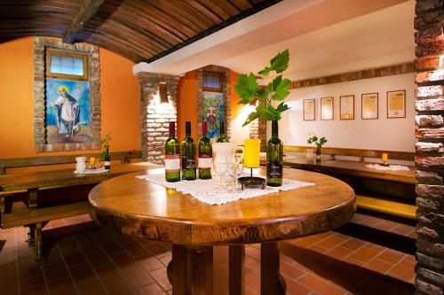 una stanza con un tavolo con bottiglie di vino di Gostišče - Guest house STARI HRAST a Ljutomer