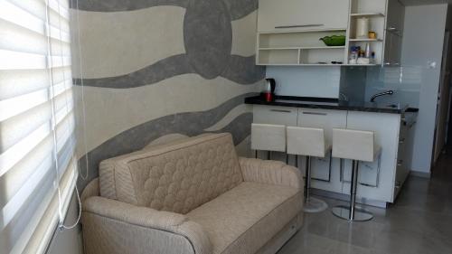 a living room with a couch and a kitchen at Apartment Ben Gurion in Bat Yam
