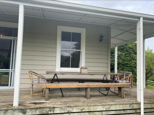 a picnic table on the porch of a house at Tui Ridge Cottage in Waiterimu