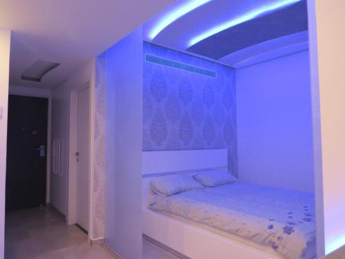 Cama en habitación con iluminación azul en Apartment Ben Gurion, en Bat Yam