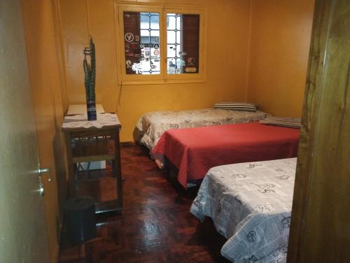 Habitación con 3 camas y ventana en La posada de Doña Teresa en Mendoza
