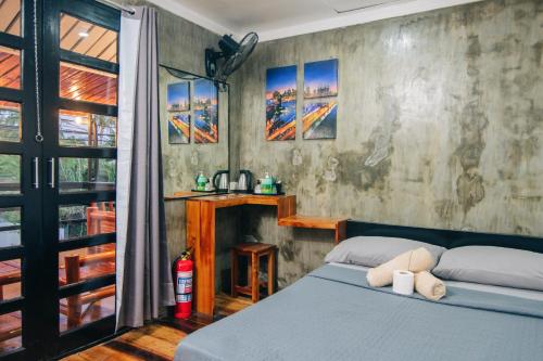 Un dormitorio con una cama azul y una ventana en OKEANOS HOTEL en Moalboal