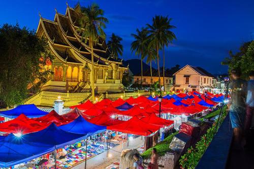 a group of red and blue umbrellas in front of a building at Mekong Chidlatda Villa in Luang Prabang