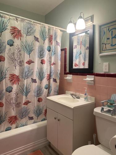 a bathroom with a sink and a shower curtain at 5 min to Beaches! Biz Ready Large Living Room Fenced Backyard Patio Grill Firepit Driveway Parking in Lake Worth