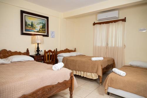 a hotel room with two beds and a window at Hotel Internacional Palmerola in Comayagua
