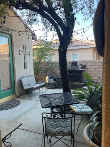 a patio with a table and chairs and a fireplace at Quaint Cochella Music Festival Casita in Indio