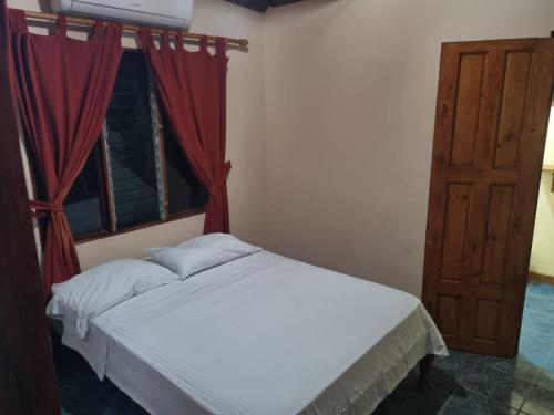 1 dormitorio con cama blanca y ventana en Cristina - Hotel Familiar, en Tambor