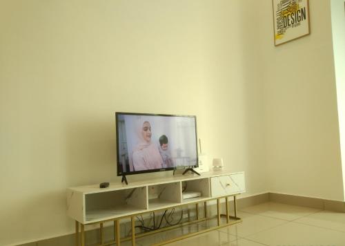 a television sitting on a stand in a living room at Armada Sweet Homestay in Gua Musang
