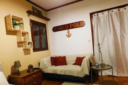 a living room with a couch and a sign on the wall at Marco Polo's Mooring Cozy Navy House in Anavissos
