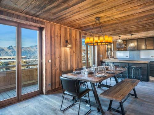une salle à manger avec une table et une grande fenêtre dans l'établissement Appartement spacieux de 4 chambres à Courchevel 1850, à 250m des remontées mécaniques et des commerces - FR-1-564-93, à Courchevel