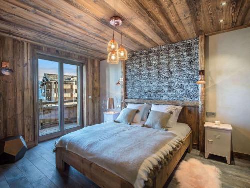 une chambre avec un grand lit avec une grande fenêtre dans l'établissement Appartement spacieux de 4 chambres à Courchevel 1850, à 250m des remontées mécaniques et des commerces - FR-1-564-93, à Courchevel