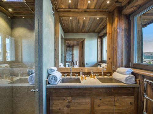 une salle de bain avec un lavabo et un grand miroir dans l'établissement Appartement spacieux de 4 chambres à Courchevel 1850, à 250m des remontées mécaniques et des commerces - FR-1-564-93, à Courchevel