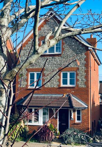 una casa de ladrillo rojo con dos ventanas. en Angmering Home, en Angmering