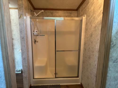 a shower with a glass door in a bathroom at Spring Time ! Cozy Getaway Cottage Pet Friendly Place in Cairo