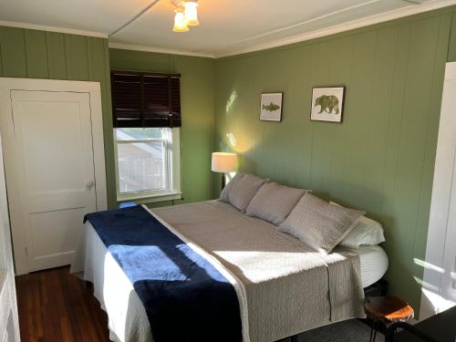 1 dormitorio con 1 cama en una pared verde en North Creek All Season Rental, en North Creek