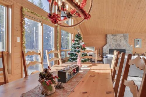 una sala da pranzo con tavolo e albero di Natale di Le Chic Harfang Mont Tremblant a Lac-Superieur