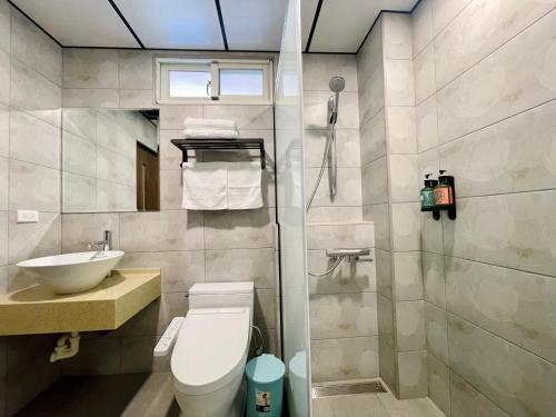 a bathroom with a toilet and a sink and a shower at Junyi Landscape Villa in Ren'ai