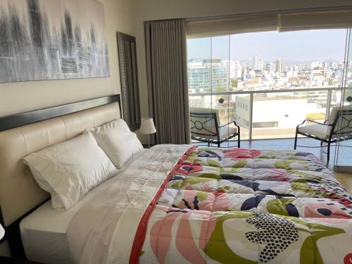 a bedroom with a bed with a view of a city at Book in Miraflores - Lima in Lima