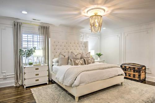 a white bedroom with a large bed and a chandelier at Stunning Charlotte Home Private Pool! in Charlotte