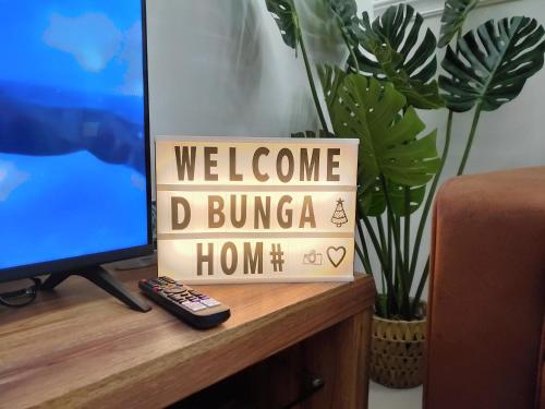 a welcome d bunza home sign next to a television at D Bunga 1 MOSLIM Homestay Pool View Legoland Nusajaya in Nusajaya