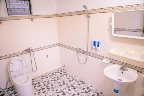 La salle de bains est pourvue de toilettes et d'un lavabo. dans l'établissement SAKURA House - Hoa Ban, à Mộc Châu