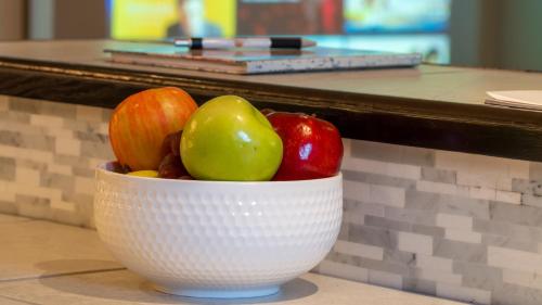 a white bowl of fruit sitting on a counter at Sunset Tides in Oak Haven