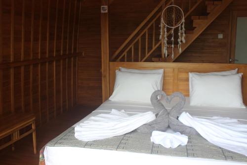a bed in a room with two towels on it at Butterfly Villas Nusa Ceningan in Nusa Lembongan