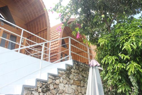 a staircase leading up to a house with an umbrella at Butterfly Villas Nusa Ceningan in Nusa Lembongan