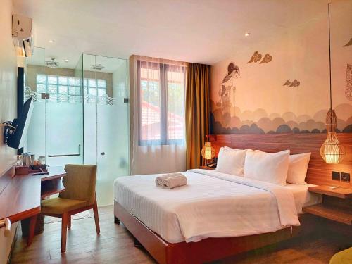 a hotel room with a bed and a desk and a bedroom at The Batu Hotel & Villas in Batu