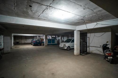 a parking garage with two cars parked in it at HOTEL PRAKAASH COMFORTS in Vānivilāsa Puram