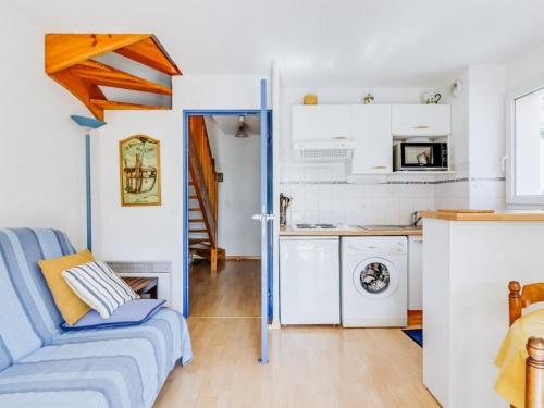 un salon avec un canapé bleu et une cuisine dans l'établissement Duplex T3 avec balcon, 2 ch, 6 pers, parking - FR-1-402-26, à Esquièze - Sère