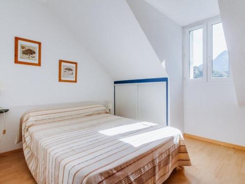 Un dormitorio con una cama en una habitación blanca. en Duplex T3 avec balcon, 2 ch, 6 pers, parking - FR-1-402-26, en Esquièze - Sère
