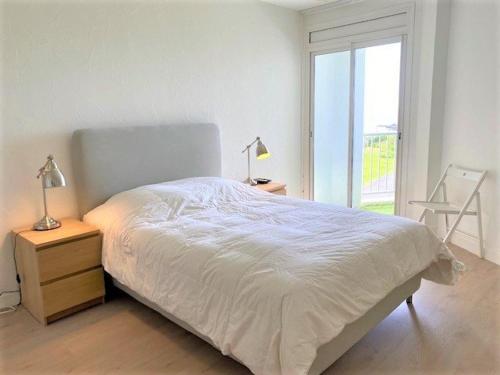 een witte slaapkamer met een bed en een raam bij Appartement Quiberon, 2 pièces, 4 personnes - FR-1-478-147 in Quiberon