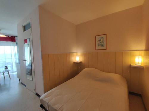 - une chambre avec un lit et deux lumières sur le mur dans l'établissement Agréable T1 proche établissement Thermal, animaux admis - FR-1-571-18, à Balaruc-les-Bains