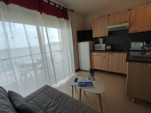 - une cuisine avec un canapé et une table dans une chambre dans l'établissement Agréable T1 proche établissement Thermal, animaux admis - FR-1-571-18, à Balaruc-les-Bains