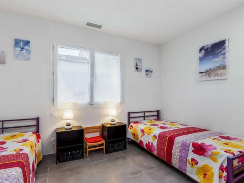 - une chambre avec 2 lits, 2 tables et une fenêtre dans l'établissement Villa T4 climatisée avec jardin, jacuzzi et Free WiFi à 600 m de la plage - FR-1-423-234, au Cap d'Agde
