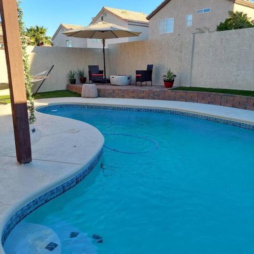 a large blue swimming pool in front of a house at New beautifully remodeled home in Las Vegas in Las Vegas