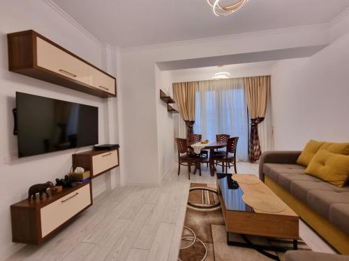 ein Wohnzimmer mit einem Sofa und einem Tisch in der Unterkunft Faleza Nord apartament de lux nou pe malul marii in Constanţa