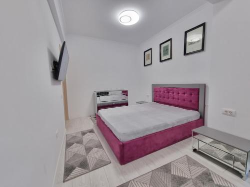 um quarto com uma cama grande e uma cabeceira de cama roxa em Faleza Nord apartament de lux nou pe malul marii em Constança