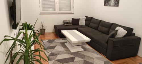a living room with a black couch and a table at Apartman Mateja in Trebinje
