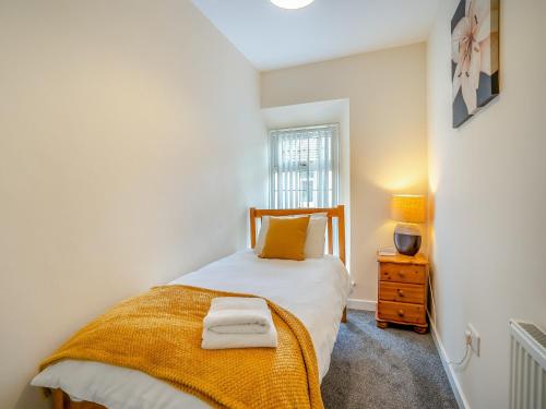 a bedroom with a bed with two towels on it at Lime House in Gorseinon