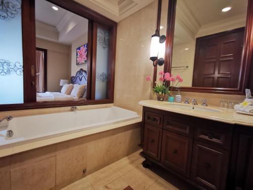 ein Badezimmer mit einer Badewanne und einem großen Spiegel in der Unterkunft Casa del Rio Residences in Malakka