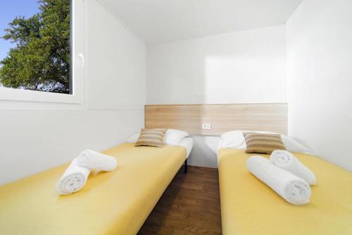 two beds sitting next to each other in a room at Caravan park Paklenica Starigrad Paklenica - CDN05014-MYA in Starigrad-Paklenica