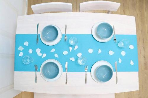 a table with plates and cutlery on a blue and white table at MishukuOnna201 in Onna