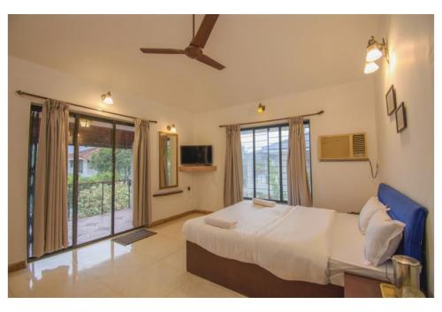 um quarto com uma cama e uma grande janela em Vinayak 5Bhk Villa Lonavala em Lonavala