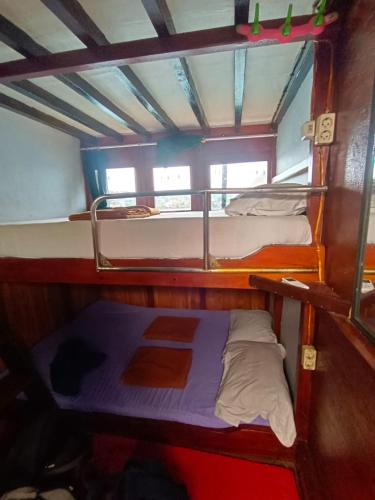 two bunk beds on a boat with at Share/Open trip komodo 2Days 1 Night in Labuan Bajo