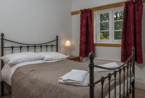 Un dormitorio con una cama grande y una ventana en Vicarage Cottage, en Kenton