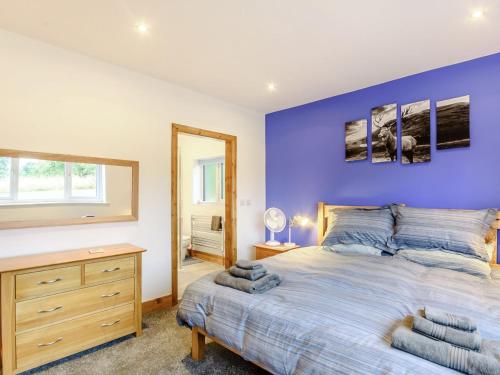 um quarto com uma cama grande e uma parede azul em Bournes Homestead em Hagwothingham